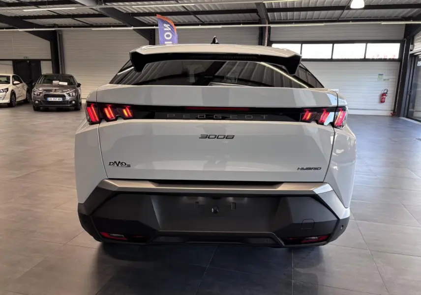 Vue arrière d'un Peugeot 3008 blanc hybride avec feux arrière LED en forme de griffes et bandeau noir laqué.