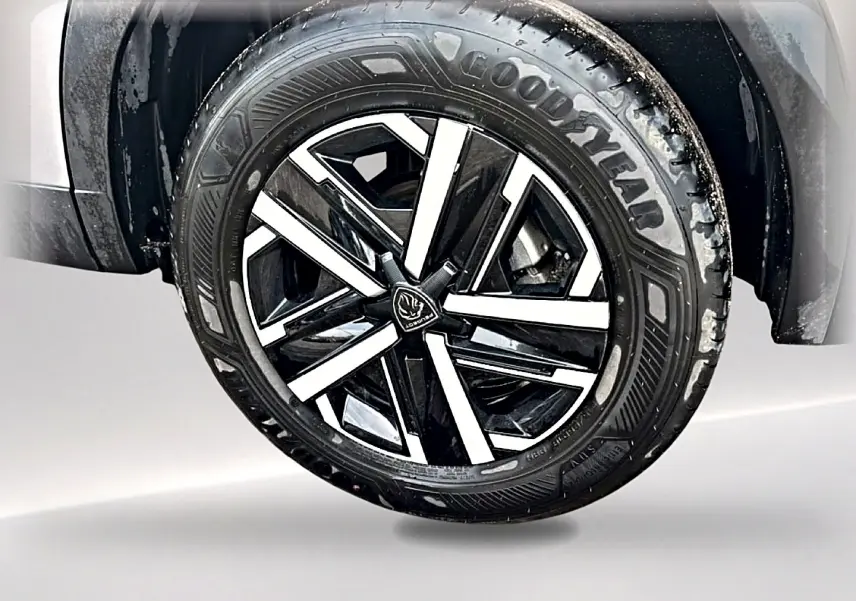 Gros plan sur la roue avant droite du Peugeot 2008 gris, mettant en valeur la jante noire et argentée au design moderne.