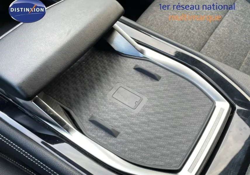 Gros plan sur la console centrale avec surface de charge sans fil et accoudoir en cuir noir du Renault Espace gris schiste.