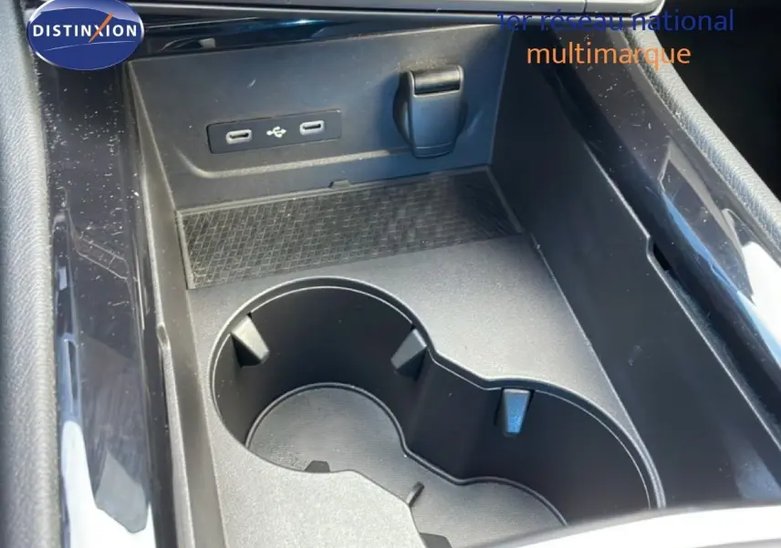 Gros plan sur la console centrale noire du Renault Espace 2024, avec porte-gobelets et ports USB visibles.