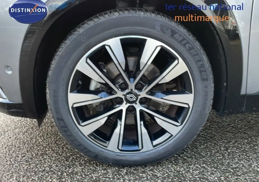 Gros plan sur la roue avant droite du Renault Espace 2024 gris schiste métal avec jante alliage bicolore.