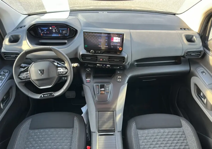 Vue intérieure avant du Peugeot Rifter GT Plus 2025, tableau de bord moderne avec écran tactile et volant cuir multifonctions.