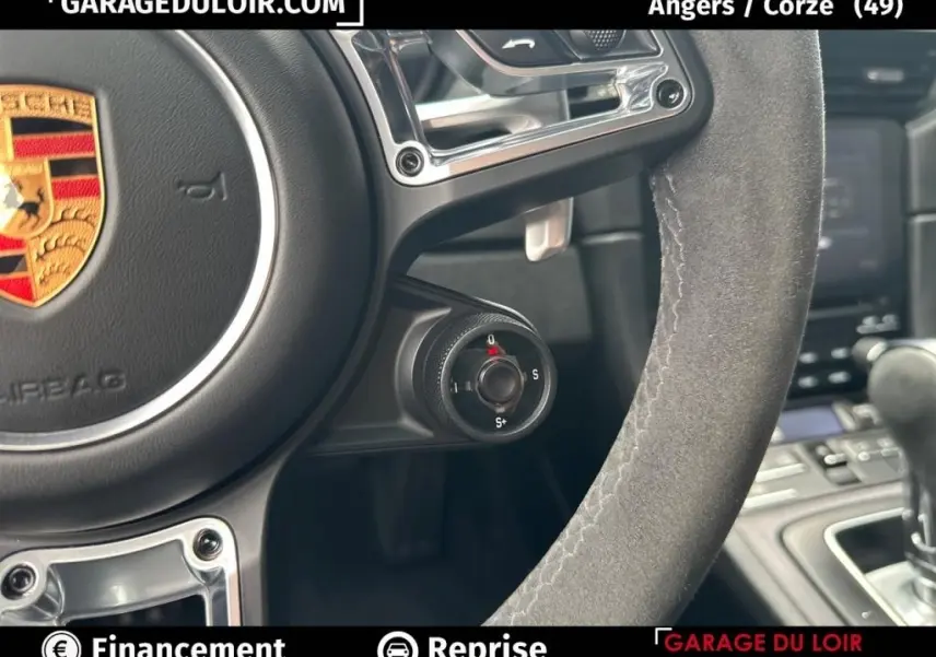 Gros plan sur le volant en alcantara gris de la Porsche 911 Carrera GTS Coupé 2018 avec sélecteur de mode de conduite.