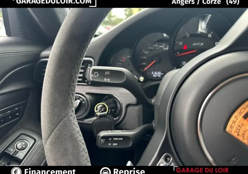 Vue rapprochée du volant en alcantara et du tableau de bord noir avec compteurs GTS de la Porsche 911 Carrera GTS Coupé 2018.