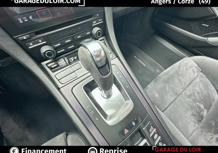 Vue rapprochée de la console centrale et du levier de vitesse gris foncé dans l'habitacle noir de la Porsche 911 Carrera GTS Coupé.