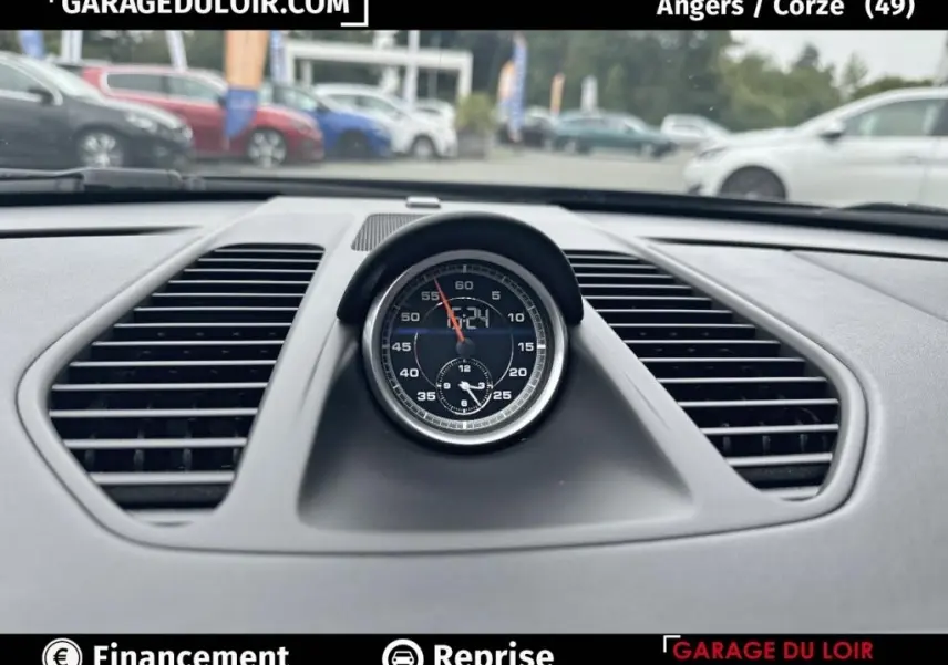 Gros plan sur l’horloge centrale noire du tableau de bord d’une Porsche 911 Carrera GTS Coupé 2018, intérieur gris.