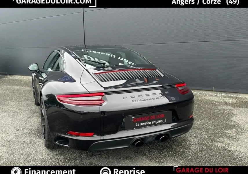 Vue 3/4 arrière droite de la Porsche 911 Carrera GTS Coupé noire, avec feux arrière LED et double sortie d’échappement centrale.