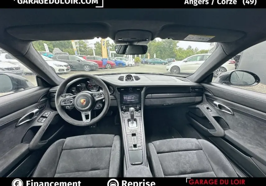 Vue intérieure avant de la Porsche 911 Carrera GTS Coupé 2018, sièges et volant en alcantara noir, tableau de bord moderne.