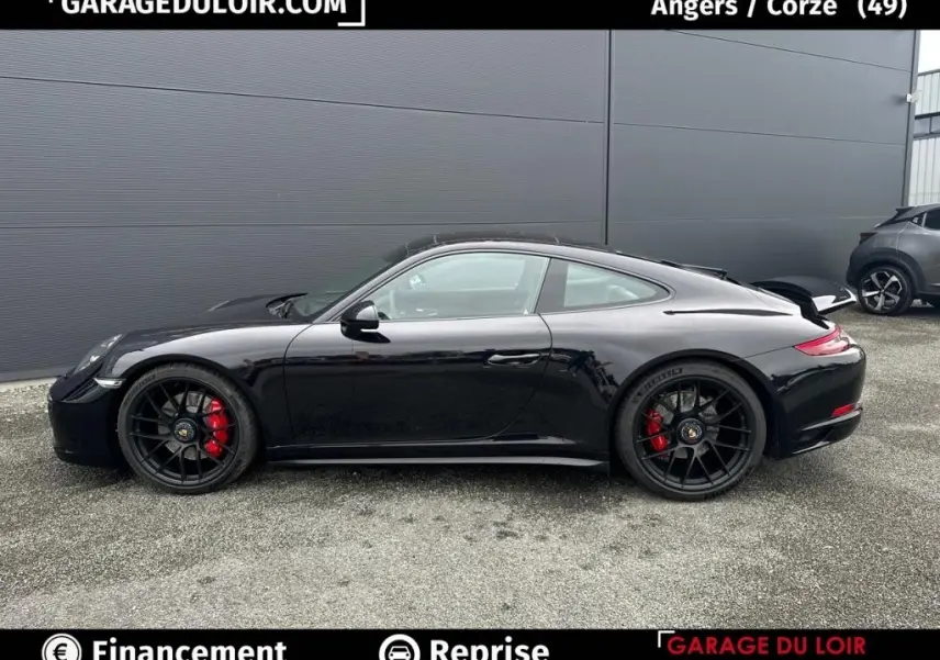 Vue latérale droite d'une Porsche 911 Carrera GTS Coupé noire avec jantes noires et étriers de frein rouges.