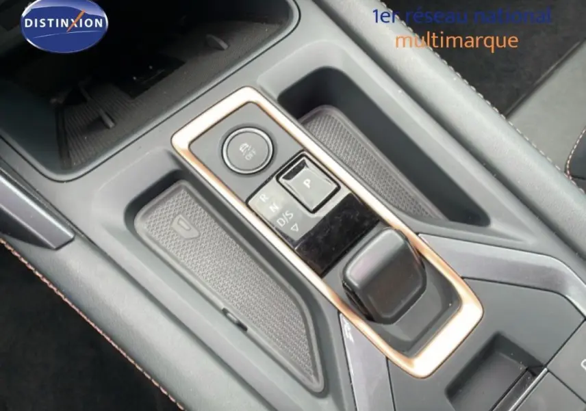 Gros plan sur la console centrale avec levier de vitesses automatique et bouton de contrôle, intérieur gris du CUPRA Formentor.