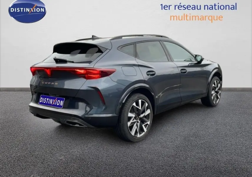 Vue 3/4 arrière droite d'un CUPRA Formentor gris 2025 avec jantes aluminium et barres de toit visibles.