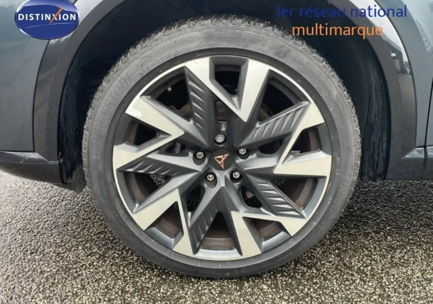 Gros plan sur la jante aluminium gris foncé du côté gauche du CUPRA Formentor gris avec logo central distinctif.