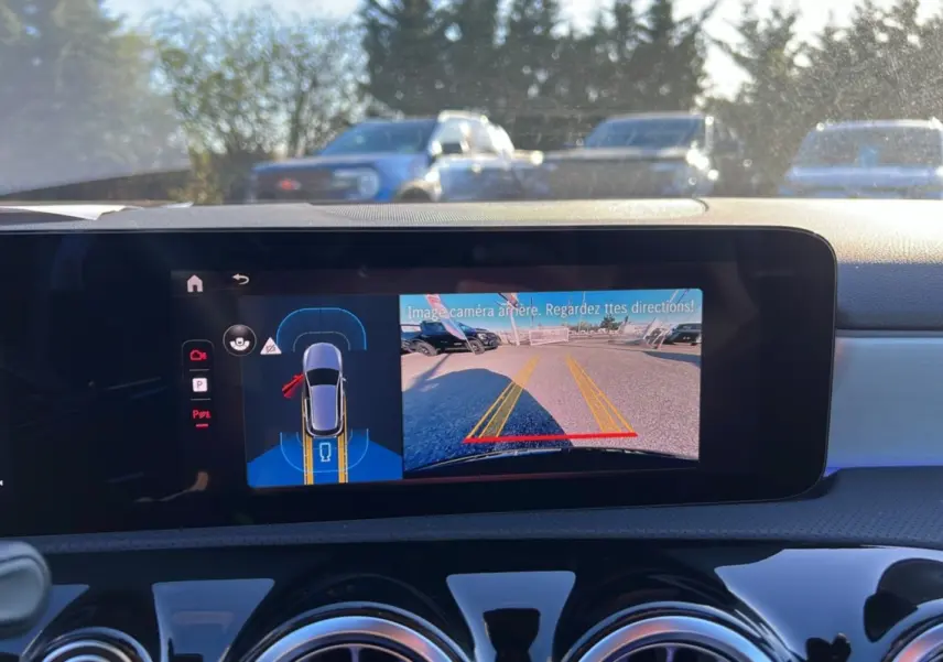 Vue intérieure du tableau de bord d'une Mercedes Classe A 200D Exclusive Design avec écran affichant la caméra de recul.