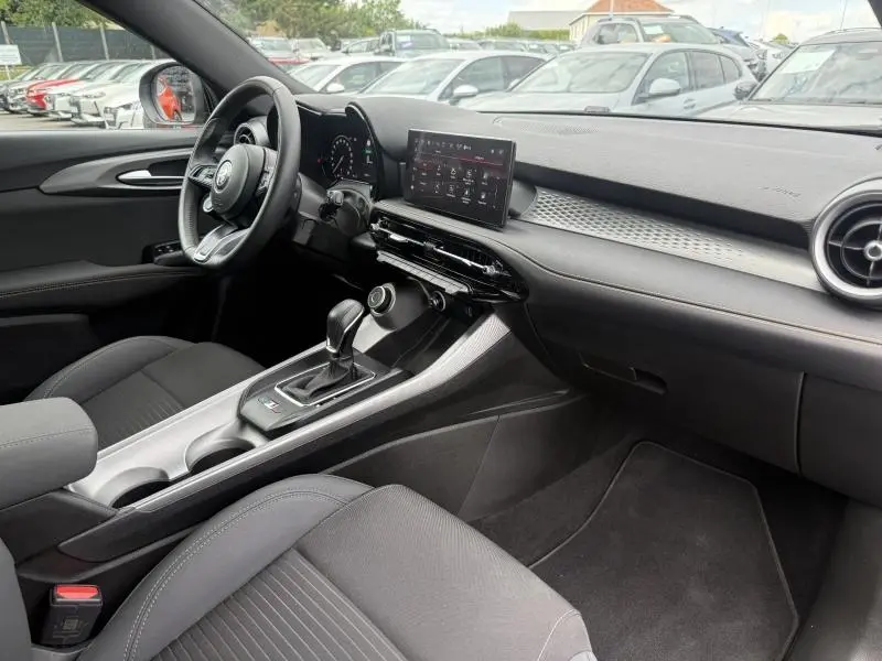 Vue intérieure côté conducteur de l'Alfa Romeo Tonale 1.5 Hybrid 130ch Sprint 2025 avec tableau de bord moderne et écran tactile.