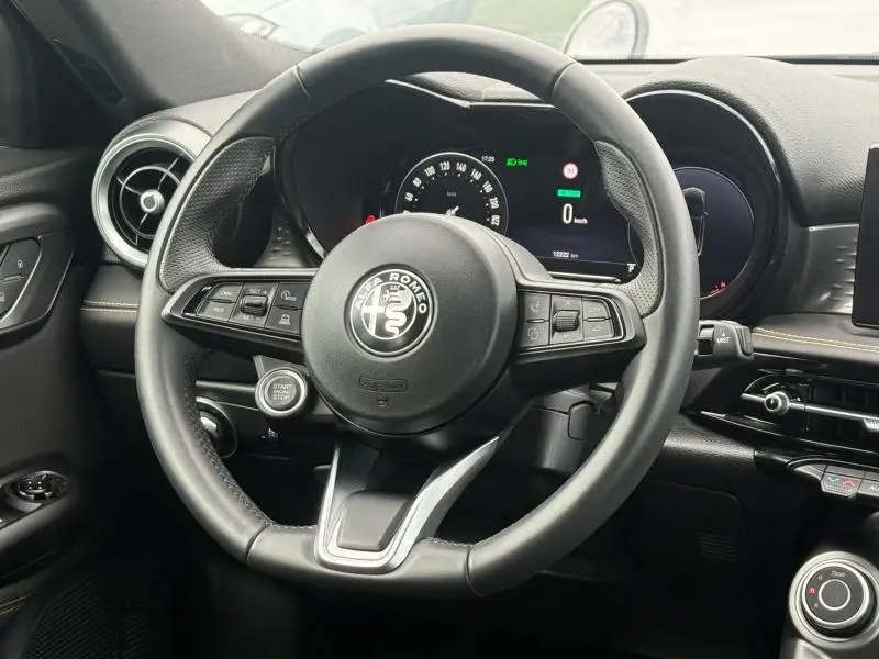 Vue rapprochée du volant cuir sport d'Alfa Romeo Tonale 1.5 Hybrid 130ch Sprint avec tableau de bord numérique.