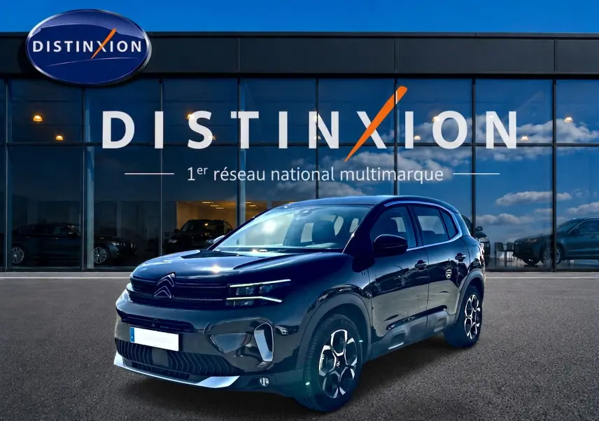 Citroën C5 Aircross noir vue 3/4 avant, avec jantes alu et calandre distinctive devant showroom Distinxion.