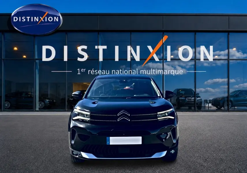 Vue frontale d'un Citroën C5 Aircross noir 2024 avec feux LED et calandre distinctive, devant une vitrine Distinxion.