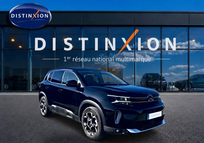 Citroën C5 Aircross hybride noire vue en 3/4 avant droit devant un showroom Distinxion.