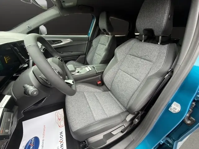 Vue intérieure côté conducteur du Renault Austral bleu, mettant en valeur les sièges tissu gris et la console centrale moderne.