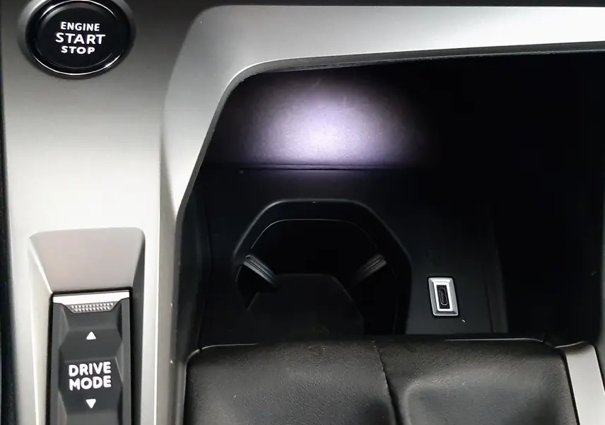 Vue rapprochée de la console centrale de la Peugeot 308 blanche, montrant le bouton Engine Start Stop et le sélecteur Drive Mode.