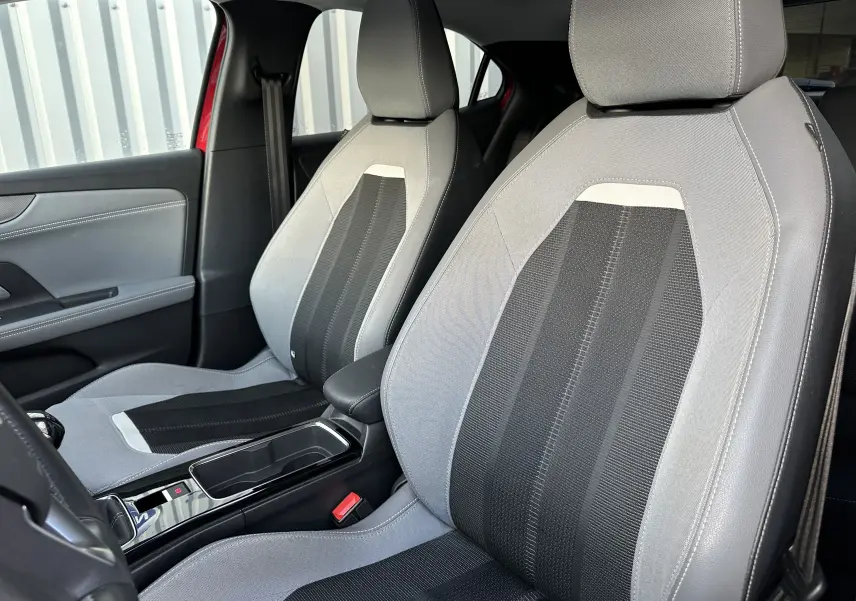 Vue intérieure des sièges avant gris et noir de l'Opel Mokka Rouge Kardinal, mettant en valeur les finitions modernes et le détail des textures.