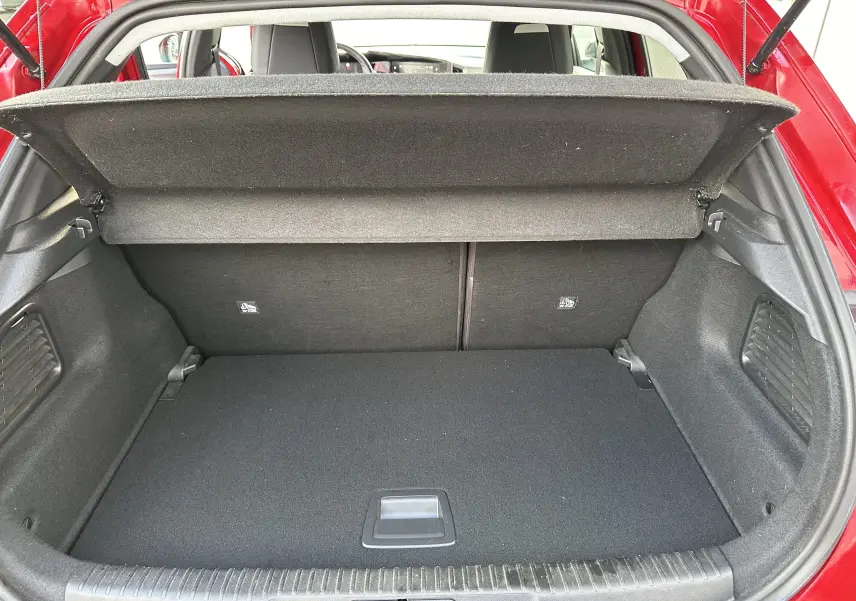 Coffre ouvert de l'Opel Mokka rouge Kardinal, vue arrière montrant un espace de chargement propre et bien agencé.
