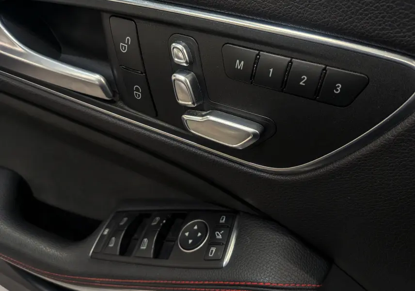 Détail des commandes de réglage électrique des sièges et des vitres côté conducteur d'une Mercedes Classe CLA 200 Fascination.
