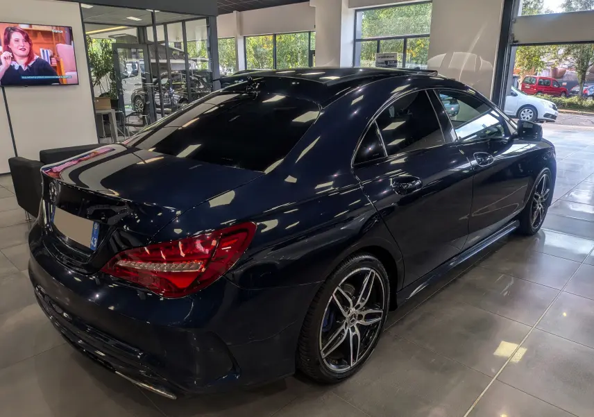 Mercedes Classe CLA 200 Fascination bleu Cavansite vue 3/4 arrière droit en showroom avec jantes AMG bicolores.