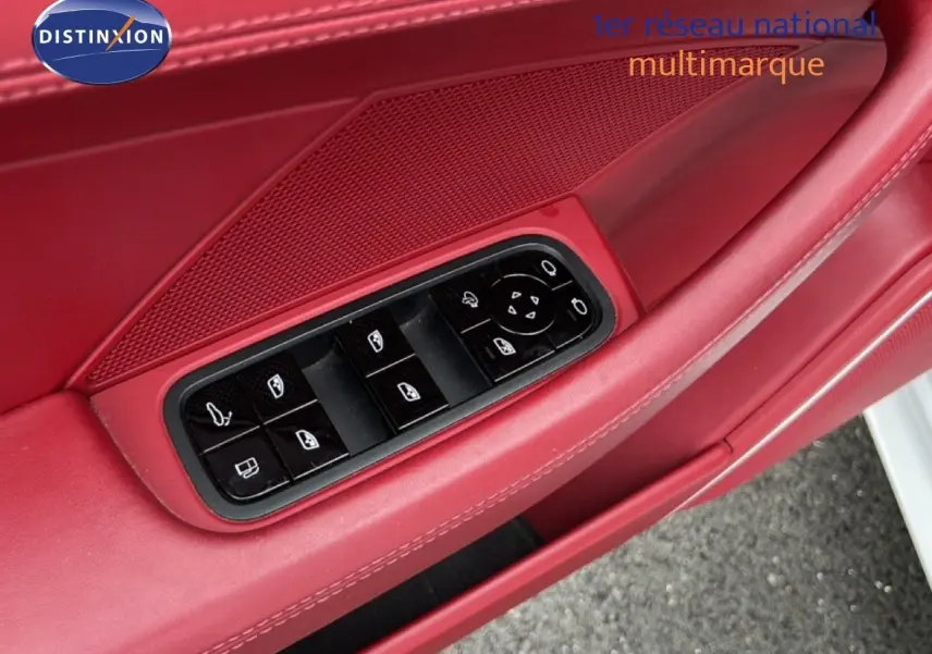 Gros plan sur la garniture rouge de la porte avant gauche d'une Porsche Panamera 4 E-Hybrid avec commandes électriques des vitres.