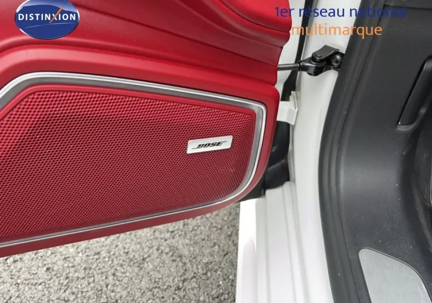 Gros plan sur la porte avant gauche blanche d'une Porsche Panamera 4 E-Hybrid avec enceinte Bose intégrée en rouge.