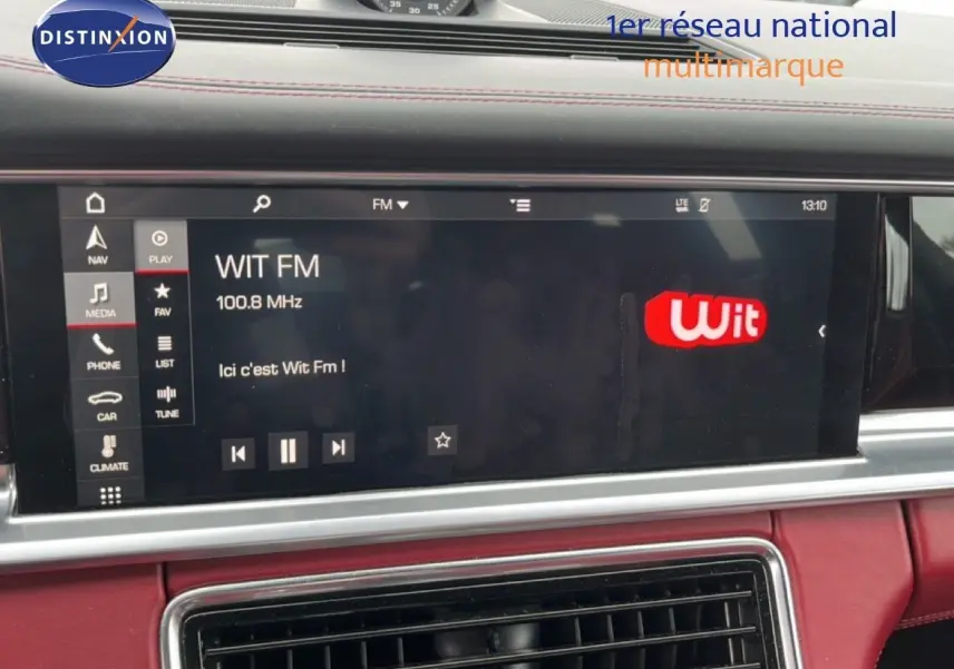 Écran multimédia central affichant la radio Wit FM dans l’habitacle rouge cuir du Porsche Panamera 4 E-Hybrid.