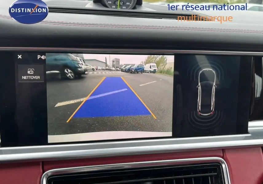 Affichage de la caméra de recul et capteurs de stationnement sur l'écran du tableau de bord d'une Porsche Panamera 4 E-Hybrid blanche.