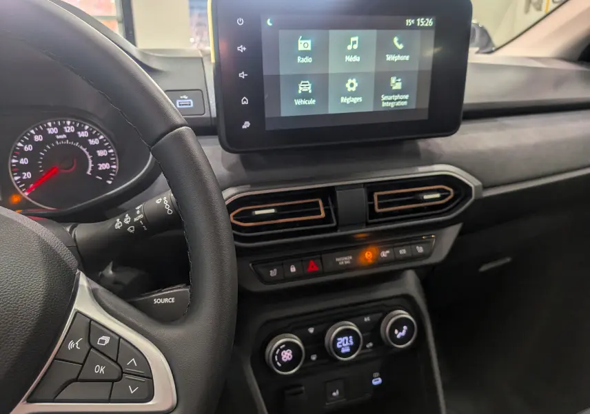 Vue intérieure centrée sur le tableau de bord et l'écran tactile de la Dacia Sandero Stepway TCe 110 vert cèdre 2025.