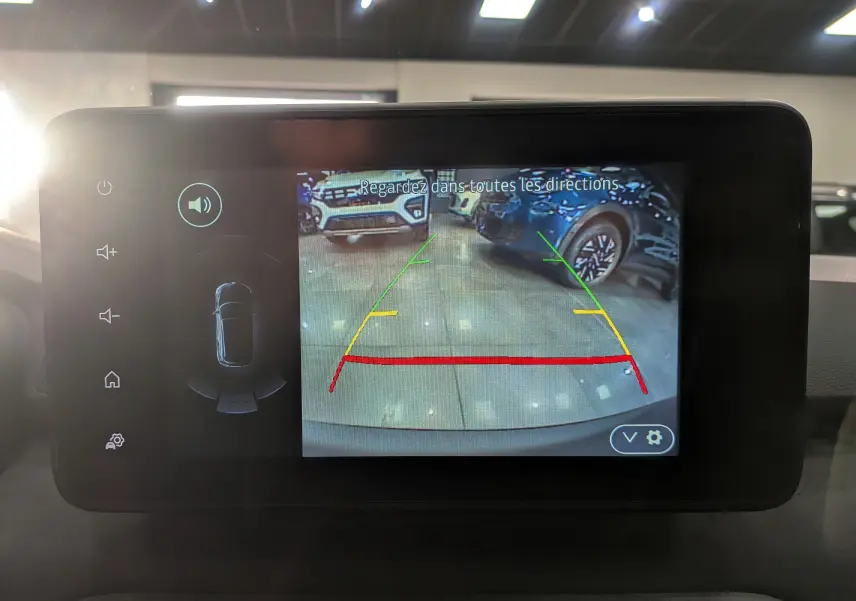 Écran multimédia affichant la caméra de recul du Dacia Sandero Stepway TCe 110 Vert Cèdre en intérieur showroom.