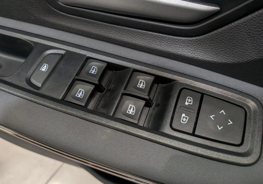 Gros plan sur les commandes des vitres et des rétroviseurs électriques dans une Dacia Sandero Stepway TCe 110 CH Extreme 2025.
