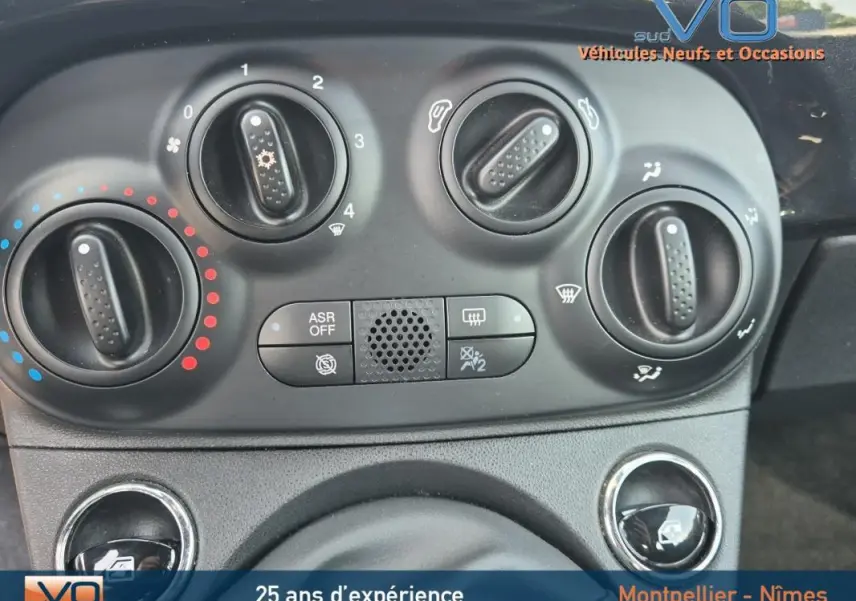 Gros plan sur les commandes de climatisation de la FIAT 500C noire 2024, avec boutons rotatifs et options visibles.