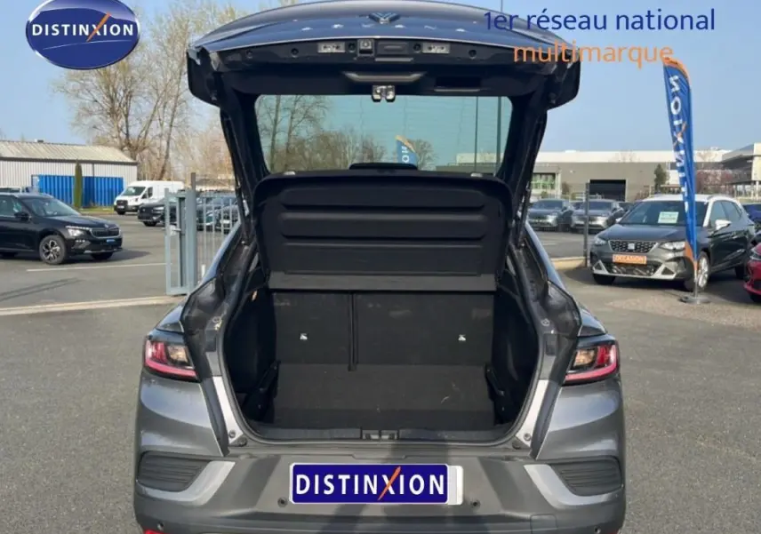 Vue arrière d’un Renault Arkana gris 2025 avec coffre ouvert et intérieur de coffre visible en extérieur.