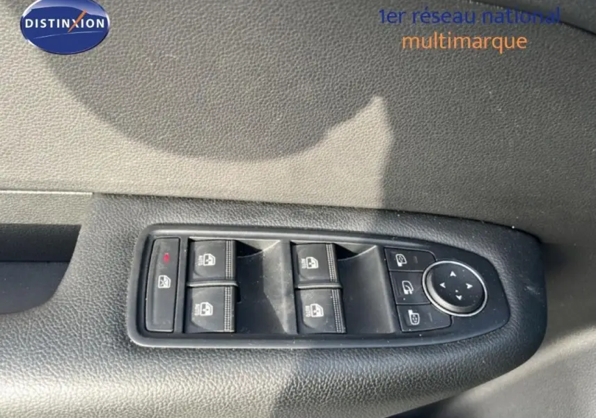 Gros plan sur les commandes des vitres électriques et rétroviseurs du côté gauche d’un Renault Arkana gris 2025.