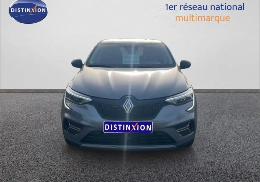 Vue frontale d'un Renault Arkana gris 2025 avec calandre noire et feux LED allumés sur fond neutre.