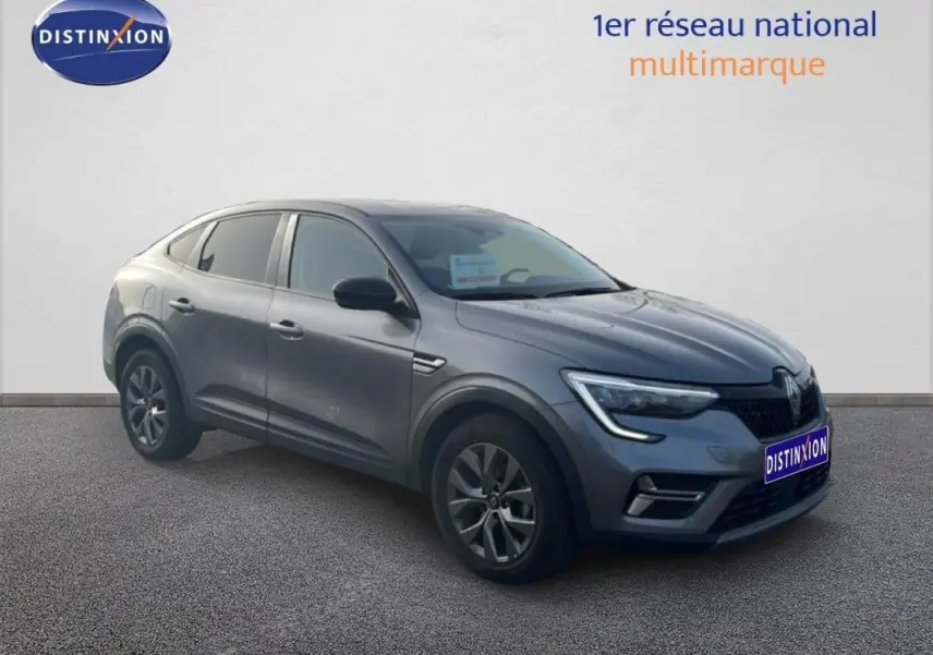 Renault Arkana gris en 3/4 avant droit, avec jantes aluminium 17 pouces et feux LED en forme de C.