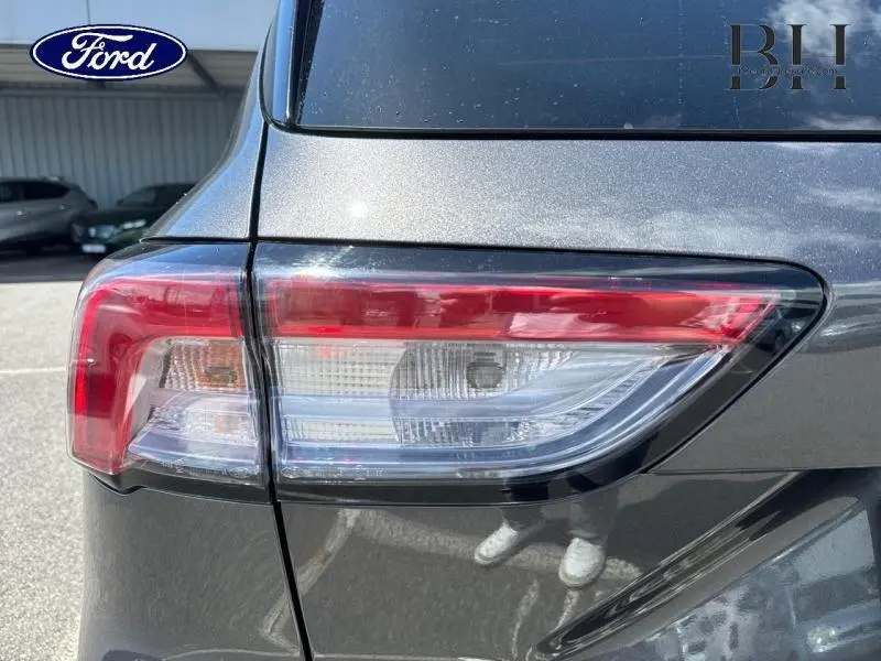 Gros plan sur le feu arrière droit du Ford Kuga 2022 gris Magnetic Métallisé avec vitres arrière surteintées.