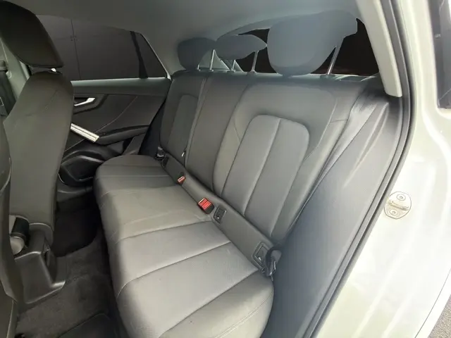 Vue intérieure du côté droit montrant la banquette arrière noire de l'Audi Q2 30 TDI 116 Design blanche de 2021.