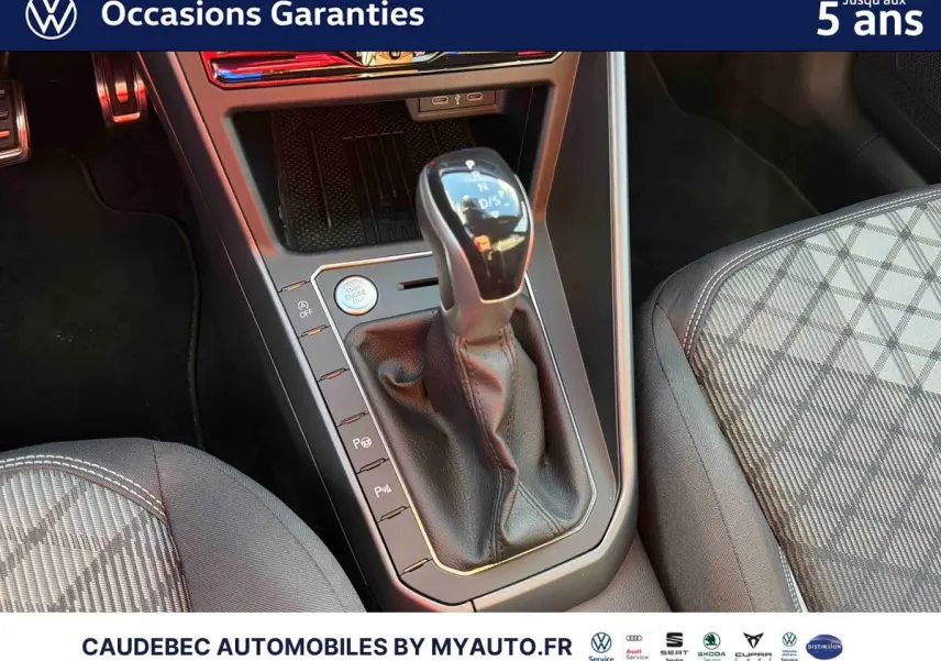 Gros plan sur le levier de vitesse automatique DSG7 en cuir dans l’habitacle de la Volkswagen Polo noire intense nacrée.