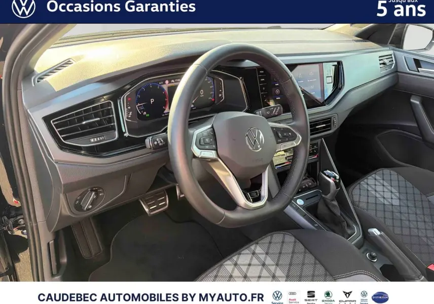 Vue intérieure avant gauche du Volkswagen Polo 2026 noir intense nacré, volant cuir et tableau de bord digital.