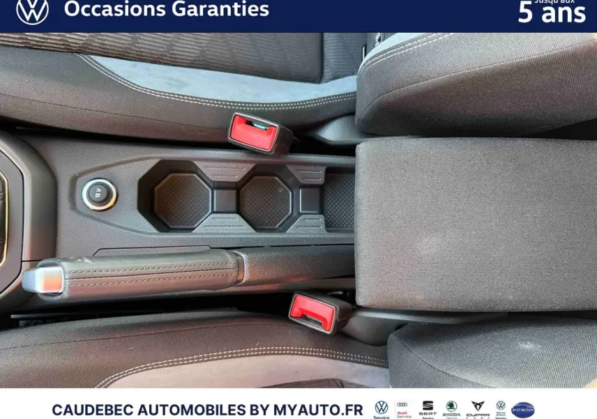 Vue rapprochée de la console centrale avec frein à main manuel et porte-gobelets de la Volkswagen Polo noire intense nacrée.