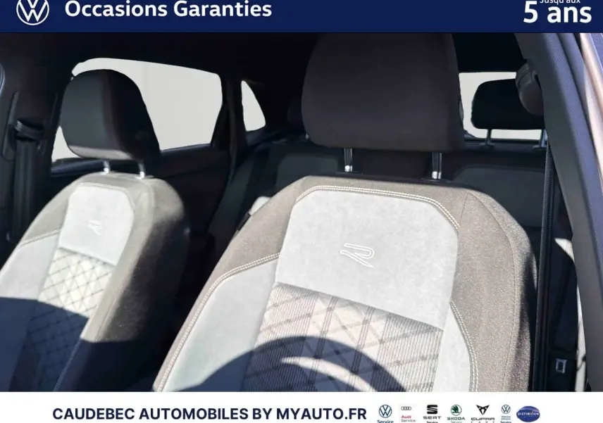 Gros plan sur les sièges avant gris clair et foncé avec logo R, intérieur d'une Volkswagen Polo noire.