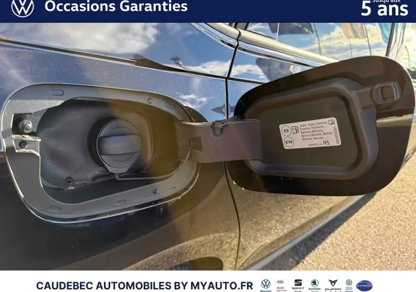 Vue rapprochée de la trappe à carburant ouverte côté gauche d'une Volkswagen Polo noire intense nacrée.