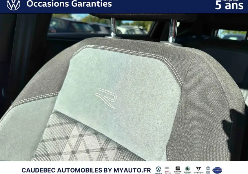 Gros plan sur l’appui-tête avant gris clair et foncé avec logo R brodé, intérieur d’une Volkswagen Polo noire.