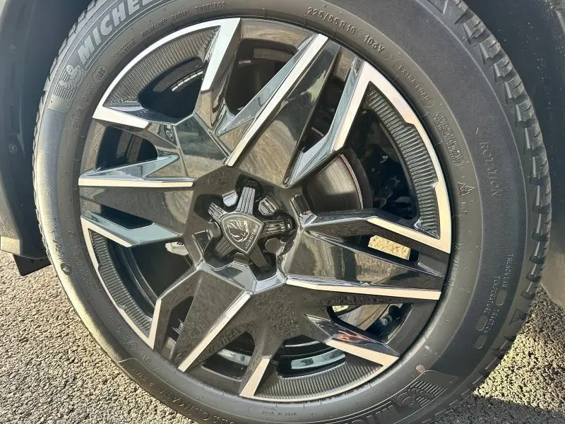 Gros plan sur la jante alu noire et argentée du Peugeot 3008 gris titane, mettant en valeur le logo central lion.