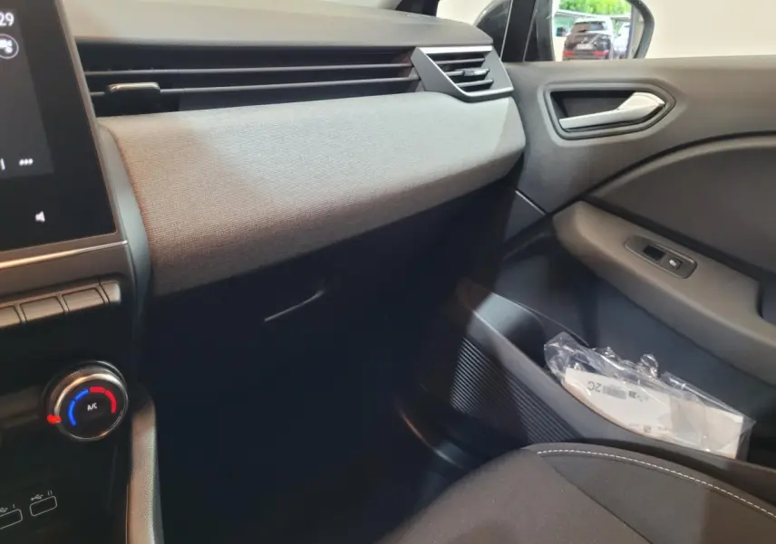 Intérieur de la Renault Clio Evolution Blue dCi 100 2025, vue côté passager avec tableau de bord gris et tissu clair.